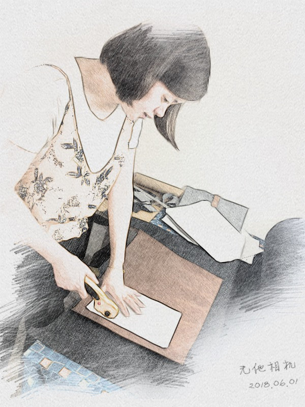 A Pisces Creation maker carefully cutting laptop sleeve material by hand